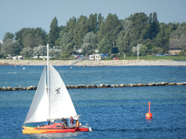 Blick auf ein Segelboot in der Hafeneinfahrt aus der Ferienwohnung Piccolo Seiss am Südstrand von Fehmarn