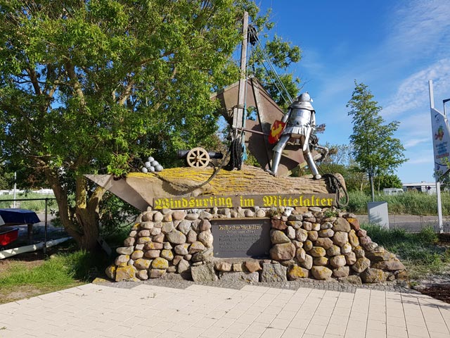 Denkmal Windsurfing im Mittelalter vor der Surfschule Charchulla am Yachthagen Binnensee Burgtiefe Fehmarn