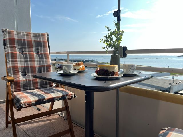 Kaffee genießen mit leckerem Kuchen von der Tortenbotschaft auf dem Balkon mit fantastischem Meerblick am Südtrand von Fehmarn